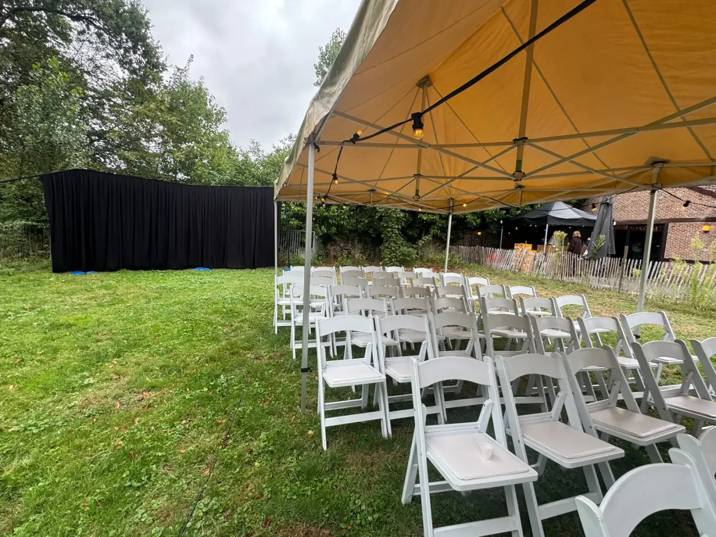 Witte klapstoelen in rijen opgesteld op het gras voor een ceremonie, een nette oplossing om meubilair te huren voor een trouwfeest in Ranst