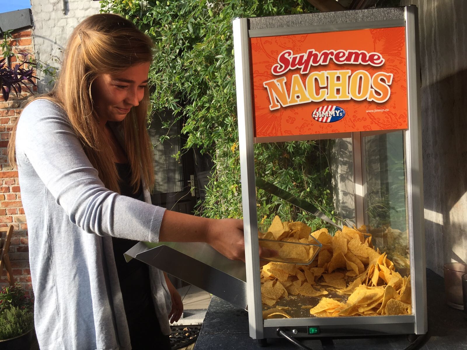 Meisje schept nacho uit nachomachine