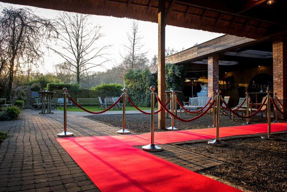Rode loper met afzetpalen voor inkom